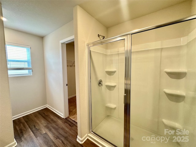 bathroom with hardwood / wood-style floors and an enclosed shower