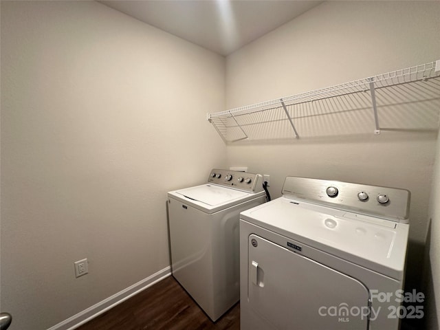 clothes washing area with washing machine and dryer and dark wood-type flooring