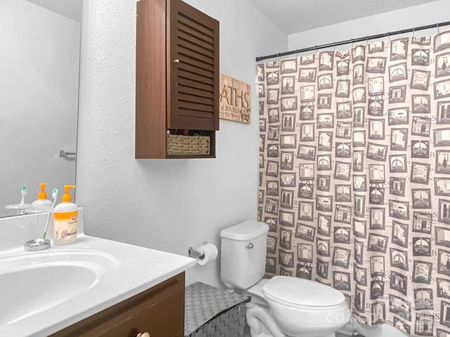 bathroom with toilet, vanity, and a shower with curtain