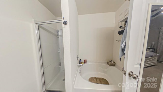 bathroom featuring shower with separate bathtub