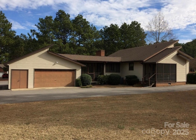 ranch-style home featuring a front lawn and a garage