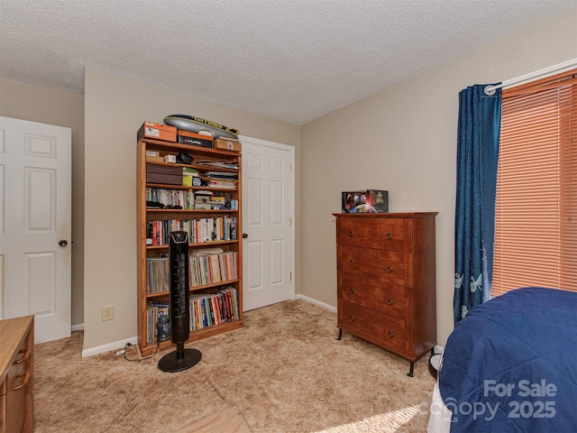 bedroom with light carpet and a textured ceiling