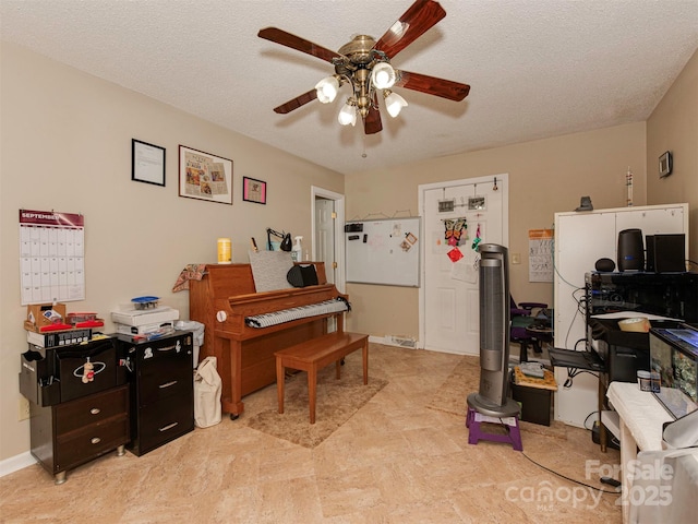 miscellaneous room featuring ceiling fan and a textured ceiling