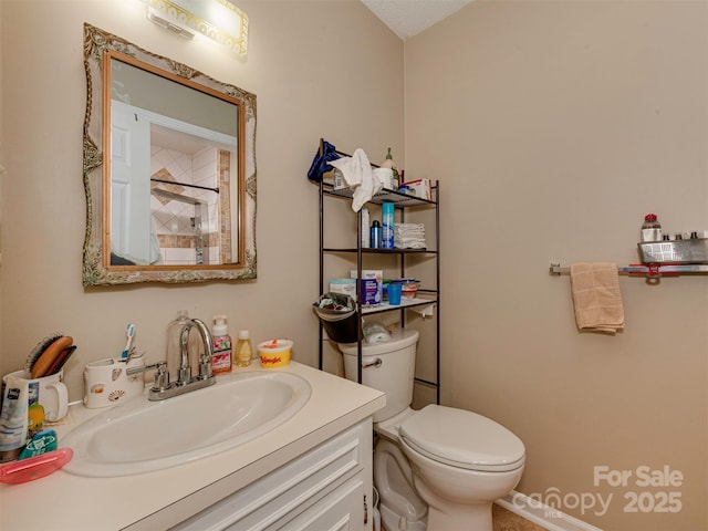 bathroom with toilet, vanity, and a textured ceiling