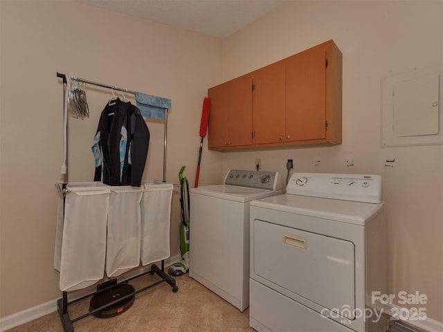 washroom featuring cabinets, electric panel, and washing machine and clothes dryer