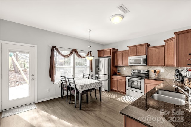 kitchen featuring a wealth of natural light, appliances with stainless steel finishes, pendant lighting, and sink