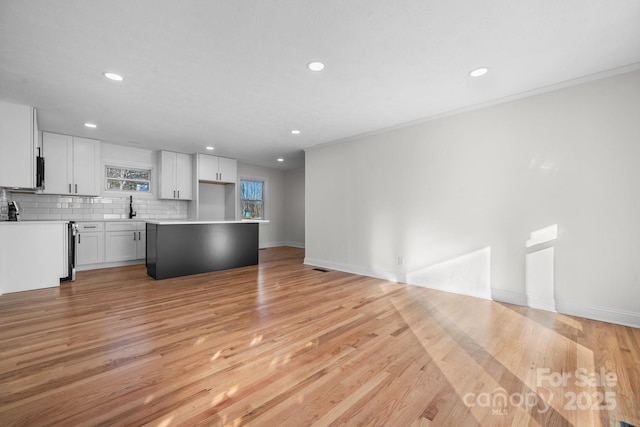 kitchen featuring backsplash, white cabinetry, and light wood-type flooring