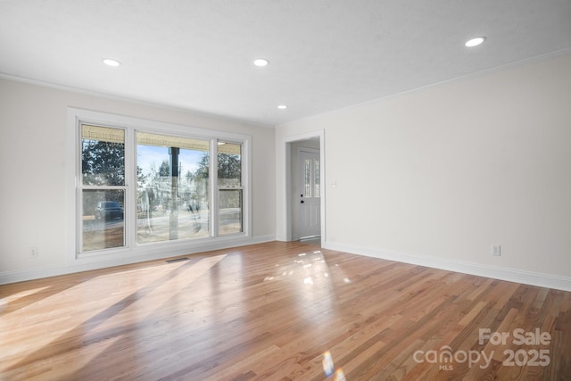 spare room with crown molding and light hardwood / wood-style flooring