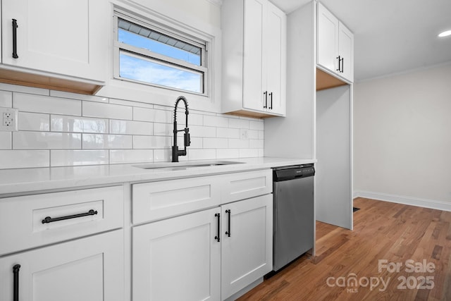 kitchen featuring dishwasher, white cabinets, backsplash, and sink