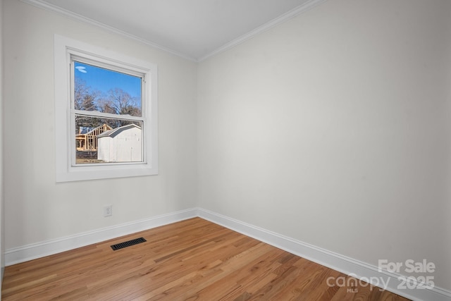 spare room with crown molding and hardwood / wood-style flooring