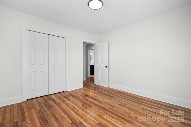 unfurnished bedroom featuring wood-type flooring and a closet