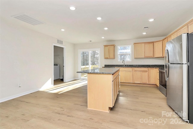 kitchen featuring appliances with stainless steel finishes, sink, light brown cabinets, and a kitchen island