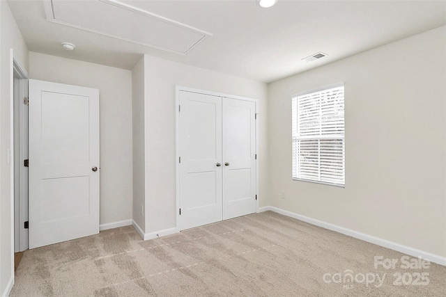 unfurnished bedroom with light carpet and a closet