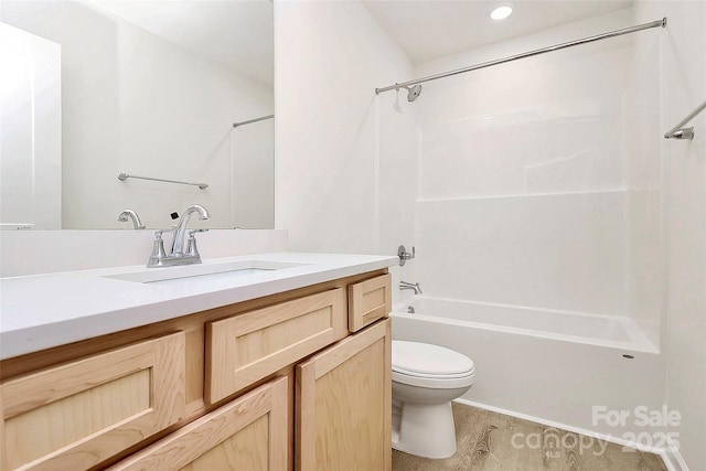 full bathroom with hardwood / wood-style flooring, toilet, vanity, and bathing tub / shower combination