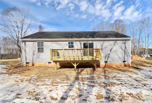 snow covered rear of property with a deck