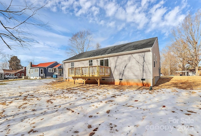 snow covered rear of property featuring a wooden deck