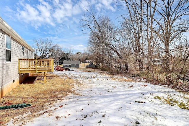 yard layered in snow featuring a wooden deck