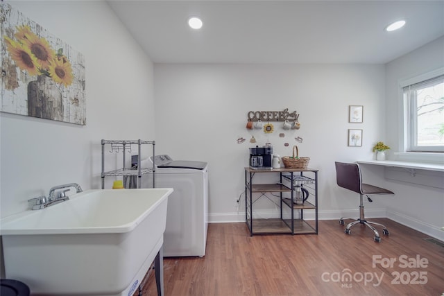 washroom featuring hardwood / wood-style flooring, sink, and washer and dryer