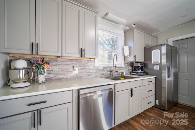 kitchen with dark hardwood / wood-style flooring, stainless steel appliances, decorative backsplash, sink, and crown molding