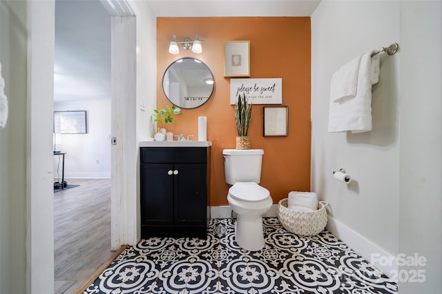 bathroom with toilet, vanity, and hardwood / wood-style flooring