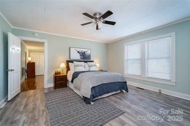 bedroom with ceiling fan, hardwood / wood-style flooring, and crown molding