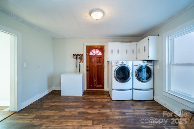 clothes washing area with washer and dryer, cabinets, dark hardwood / wood-style flooring, and ornamental molding