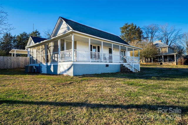 country-style home with a front yard, covered porch, and central AC unit