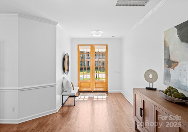 interior space with crown molding, light hardwood / wood-style flooring, and french doors