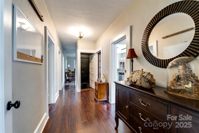 hall featuring dark wood-type flooring and a textured ceiling