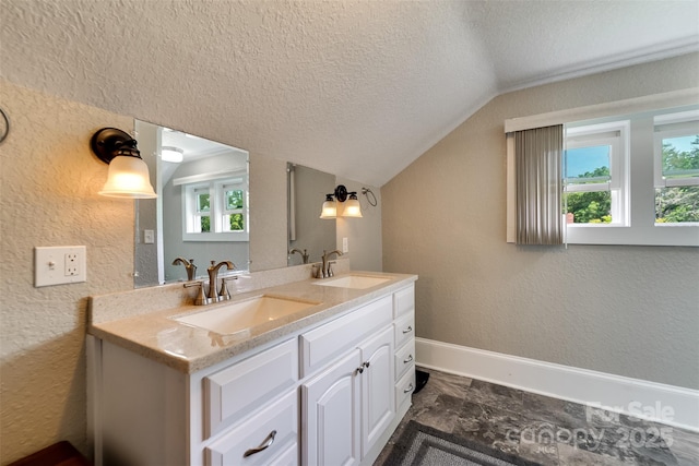 bathroom with vanity, a healthy amount of sunlight, a textured ceiling, and lofted ceiling