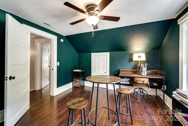 interior space with ceiling fan, dark hardwood / wood-style floors, a textured ceiling, and lofted ceiling