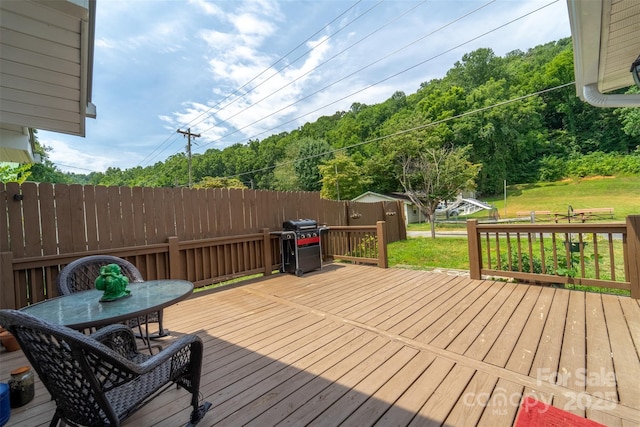 wooden terrace with a yard and grilling area