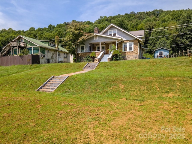 view of front of house featuring covered porch and a front yard