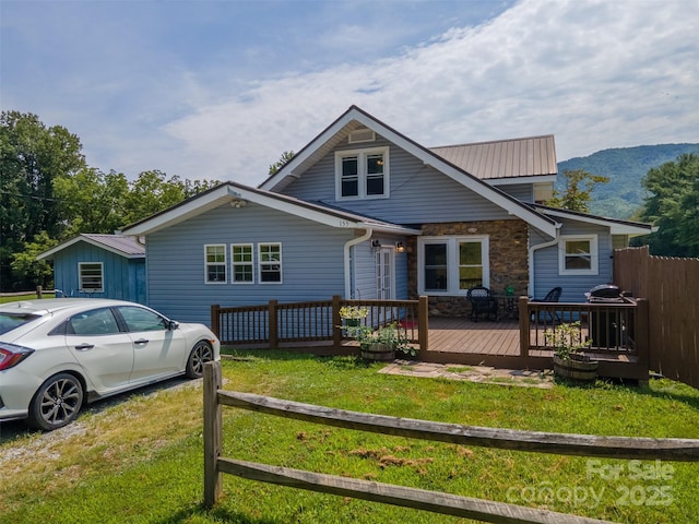 view of front facade with a front yard and a deck with mountain view