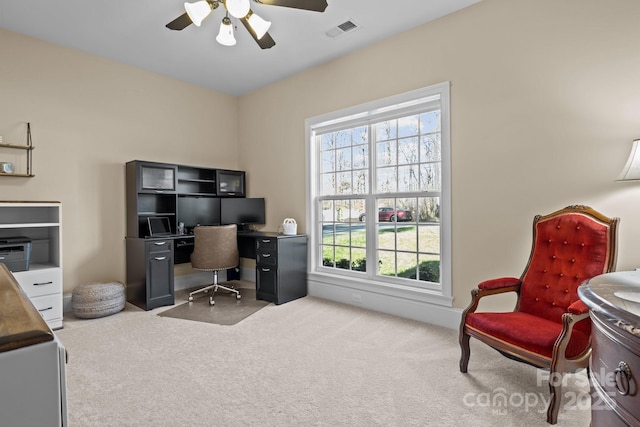 carpeted office space featuring ceiling fan