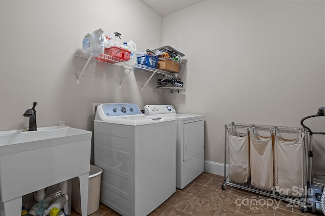 clothes washing area featuring sink and separate washer and dryer