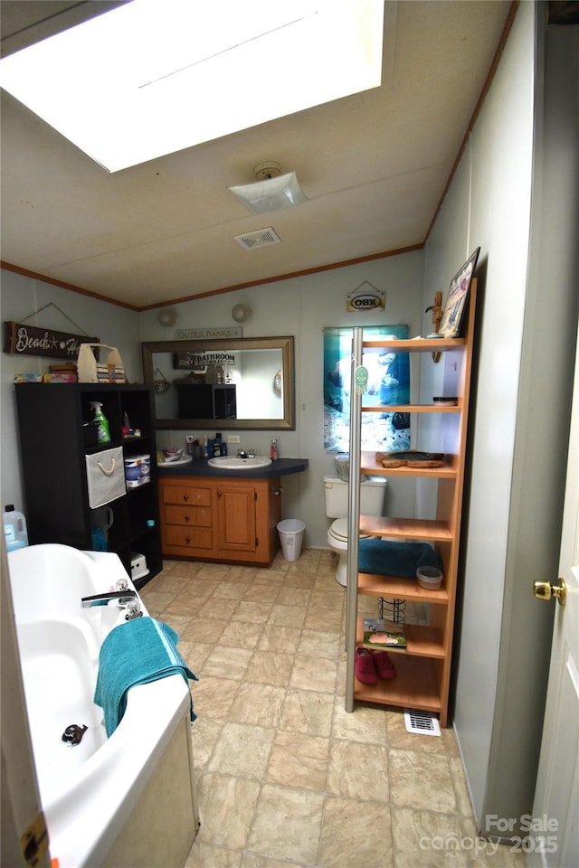 bathroom with visible vents, toilet, lofted ceiling, ornamental molding, and vanity