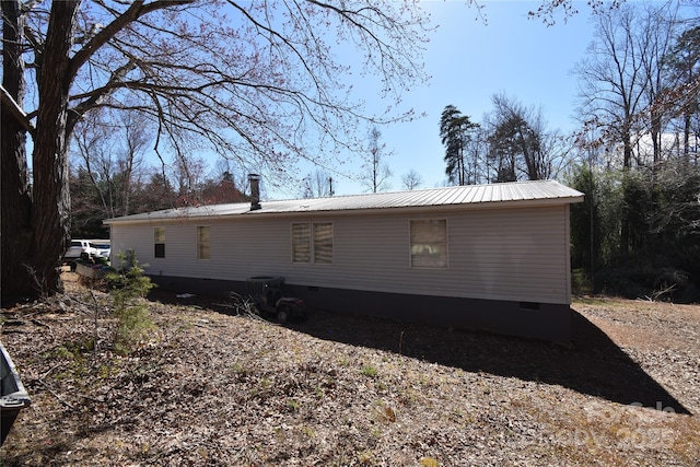 rear view of house featuring metal roof and crawl space