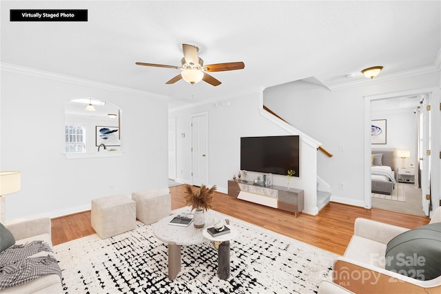 living room featuring ceiling fan, ornamental molding, and hardwood / wood-style flooring