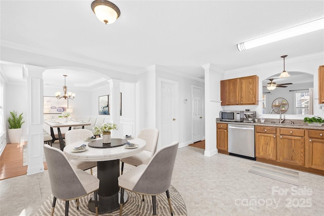 dining room featuring ceiling fan with notable chandelier, sink, and ornamental molding