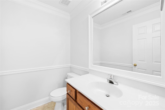 bathroom with toilet, tile patterned flooring, crown molding, and vanity