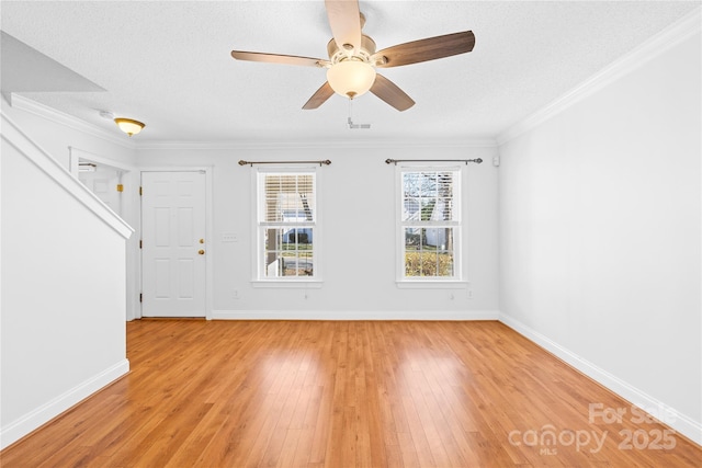 empty room with ceiling fan, a textured ceiling, light hardwood / wood-style flooring, and ornamental molding