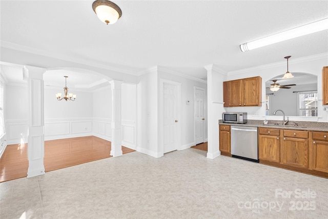 kitchen with appliances with stainless steel finishes, decorative light fixtures, crown molding, ceiling fan with notable chandelier, and sink