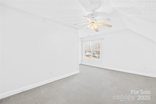 interior space featuring vaulted ceiling, ceiling fan, and a textured ceiling