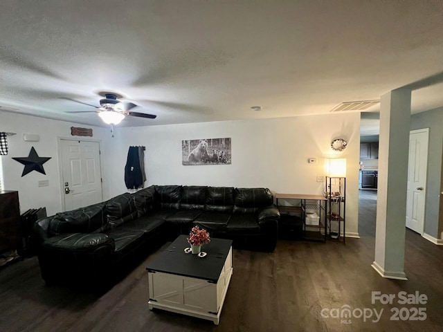 living room featuring ceiling fan, dark hardwood / wood-style flooring, and a textured ceiling