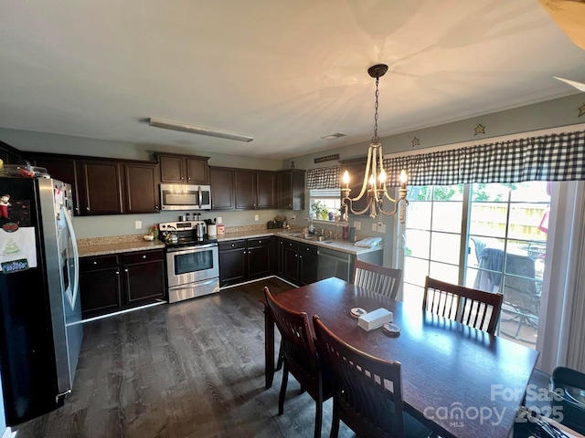 kitchen featuring dark hardwood / wood-style floors, a notable chandelier, pendant lighting, dark brown cabinetry, and stainless steel appliances