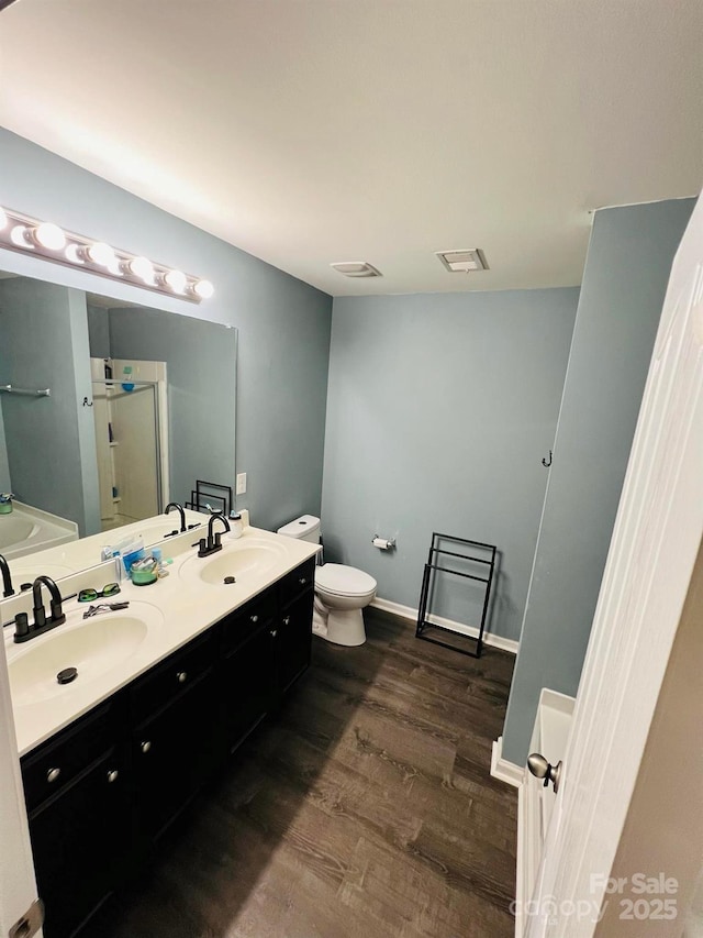 bathroom featuring toilet, vanity, and hardwood / wood-style flooring