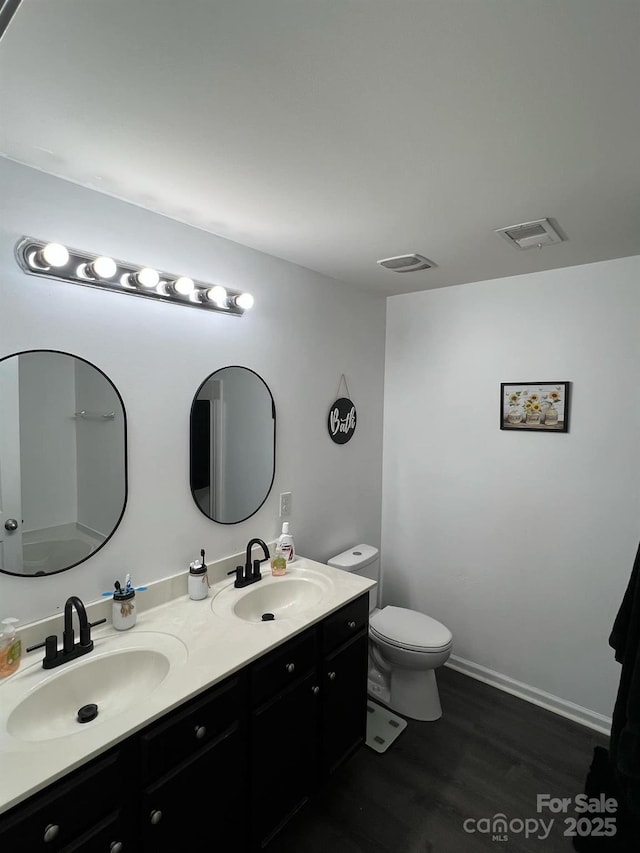 full bath featuring toilet, a sink, double vanity, and visible vents