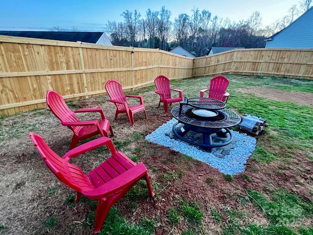 view of yard with a fenced backyard and a fire pit