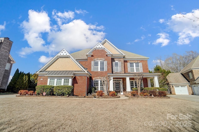 view of front facade featuring a front yard, a standing seam roof, and brick siding